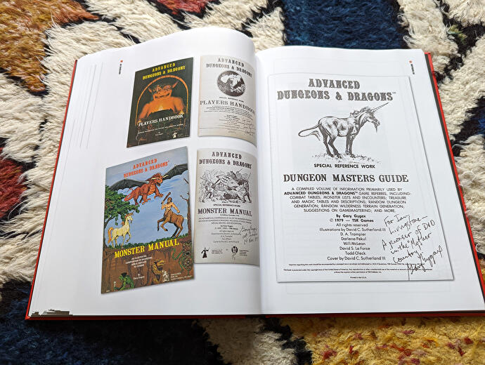 صورة من كتاب ورشة عمل Dice Men Games ، تُظهر صفحتين من أدوات Dungeons & Dragons الأصلية ، بما في ذلك نسخة من Advanced D&D موقعة من قبل المؤلف المشارك Gary Gygax.