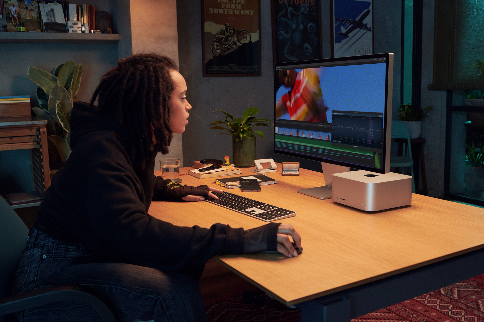 في هذه الصورة التسويقية من Apple ، تم تصوير محترف مبدع جالسًا على مكتبه ويستخدم جهاز كمبيوتر Mac Studio متصل بشاشة Studio Display